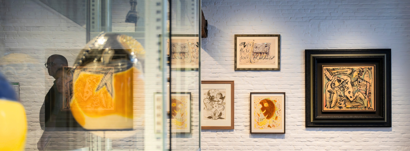 Ingelijste kunstwerken aan de muur in het CoBrA-depot.